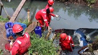 Petugas Pertamina tengah melakukan penyemprotan cairan dispertan atau melarutkan minyak dengan air pada sungai yang tercemar pipa Pertamina.