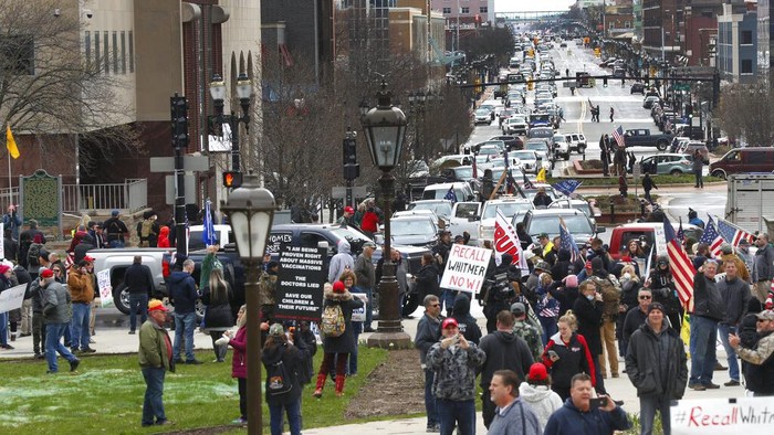 Para pendemo berunjuk rasa di depan balai kota Michigan, AS. Mereka menentang aturan lockdown seperti tetap di rumah (stay at home) yang membuat pendemo khawatir terhadap pekerjaan dan pendapatan mereka. Aturan tersebut diberlakukan hingga 30 April mendatang.