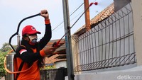 Petugas Posgab Jabar melakukan penyemprotan di pemukiman warga padat penduduk.