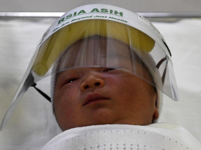 Bayi mengenakan pelindung muka atau face shield di RS Ibu dan Anak Asih, Jakarta, Jumat (17/4/2020). RSIA Asih memberikan perlindungan dini berupa pelindung muka atau face shield kepada bayi baru lahir, bayi atau anak yang melakukan imunisasi dari paparan Covid-19 saat berada di area publik rumah sakit tersebut. ANTARA FOTO/Puspa Perwitasari/pras.