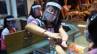 Sejumlah pegawai toko menggunakan masker dan alat pelindung wajah (face shield) di toko emas Rejeki, Pasar Bogor, Jawa Barat, Kamis (16/4/2020).