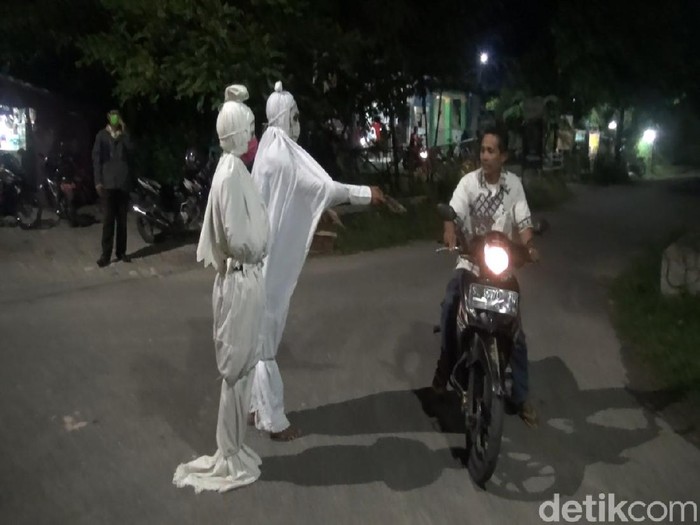 Aksi unik dilakukan warga Lamongan dalam membagikan masker untuk mencegah penyebaran virus Coroba. Mereka berdandan ala pocong seperti di film horor.