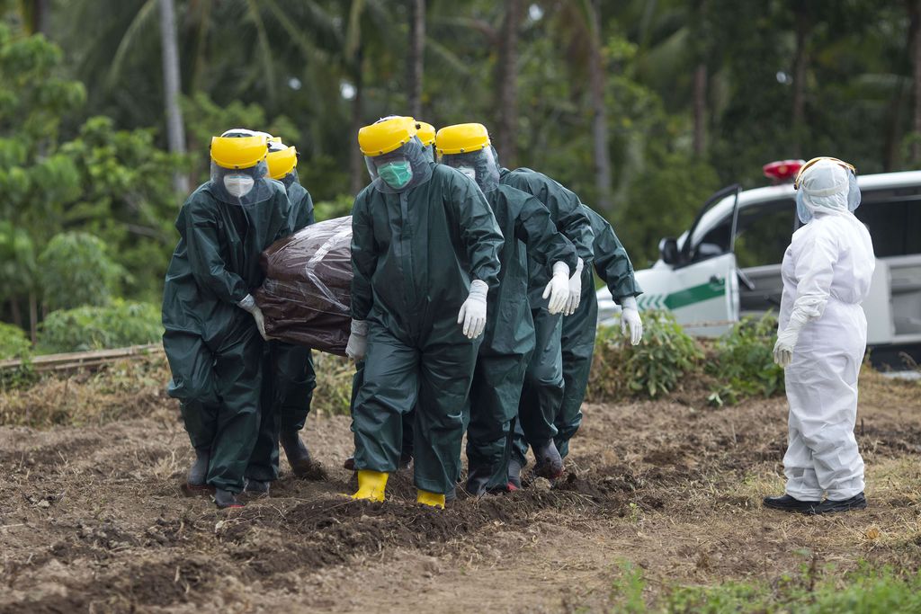 Petugas memakamkan seorang Pasien Dalam Pengawasan (PDP) COVID-19 di Kabupaten Kepulauan Sangihe, Sulawesi Utara, Jumat (17/4/2020). Pasien berjenis kelamin laki-laku dan berusia 50 tahun itu dirawat sejak tanggal 11 April 2020 di RS Liun Kendage, Tahuna, mempunyai keluhan sesak nafas, demam tinggi dan batuk. Pada hasil pemeriksaan swab pertama dinyatakan negatif dan masih menunggu hasil pemeriksaan swab yang kedua. ANTARA FOTO/Stenly Pontolawokang/wsj.