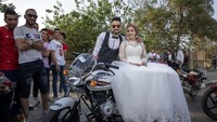 Pengantin baru berpose di atas sepeda motor freestyle. Pemerintah Kairo baru saja memberlakukan jam malam menghadapi COVID-19.