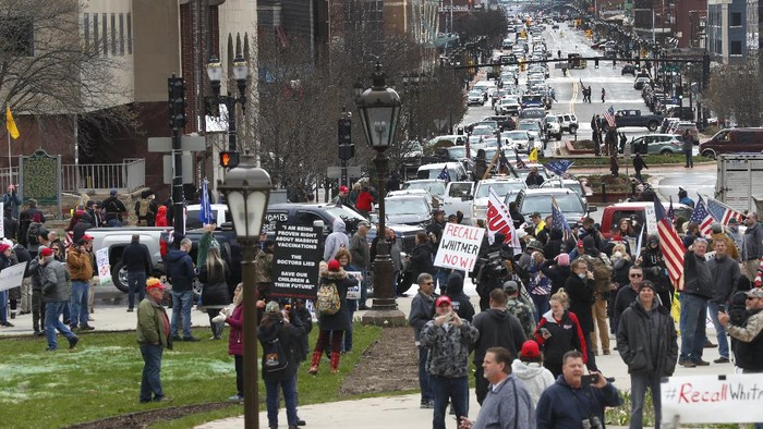 Protesters gather at the Michigan State Capitol in Lansing, Mich., Wednesday, April 15, 2020. Flag-waving, honking protesters drove past the Michigan Capitol on Wednesday to show their displeasure with Gov. Gretchen Whitmers orders to keep people at home and businesses locked during the new coronavirus COVID-19 outbreak. (AP Photo/Paul Sancya)