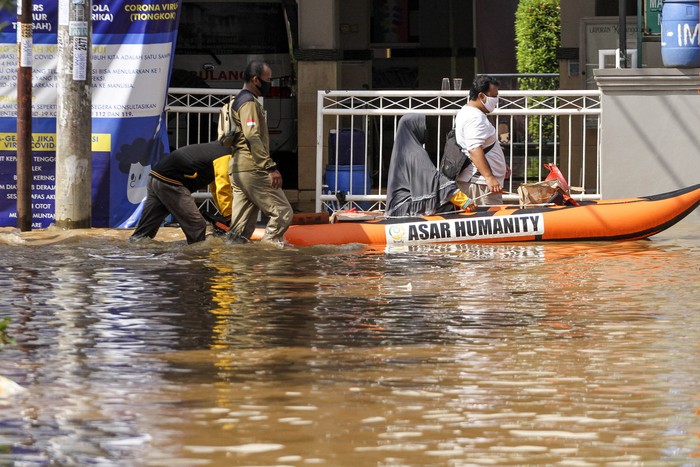 Warga melintas menggunakan perahu karet ditengah banjir di Bukit Sawangan Indah, Depok, Jawa Barat, Sabtu (18/4/2020). Banjir setinggi 60cm - 100cm tersebut disebabkan karena meluapnya aliran air kali Angke dan tanggul yang tidak mampu menahan debit air. ANTARA FOTO/Asprilla Dwi Adha/hp.