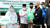 Kiai Said menyerahkan bantuan Sembako secara simbolik kepada warga setempat. Nantinya ribuan paket sembako itu akan disalurkan langsung kepada masyarakat yang terdampak di Kecamatan Jagakarsa, Jakarta Selatan. Foto: dok. PBNU
