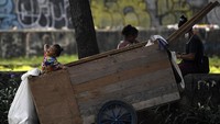  Seorang ibu bersama anak-anaknya beristirahat dengan duduk di samping gerobak di kawasan Karet, Jakarta Pusat.