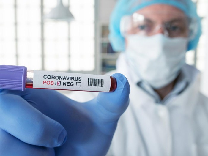 Man and woman, senior man lying in hospital bed because of coronavirus infection, female doctor is giving medicine to a patient.