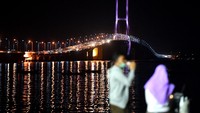 Tak seperti biasanya, hanya sedikit warga yang datang untuk menikmati senja di pantai sisi timur Jembatan Suramadu di Surabaya.