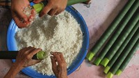 Warga memasukkan beras ketan ke dalam bambu saat proses pembuatan lemang di Desa Alue Raya, Samatiga, Aceh Barat, Aceh, Sabtu (18/4/2020). ANTARA FOTO/Syifa Yulinnas