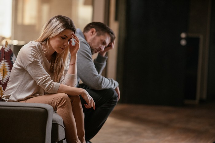 Unhappy young couple. Shallow DOF. Developed from RAW; retouched with special care and attention; Small amount of grain added for best final impression. 16 bit Adobe RGB color profile.