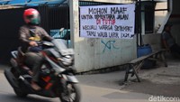 Seorang pengendara motor melintas di depan sebuah gang yang ditutup sementara guna mencegah penyebaran virus Corona di kawasan Kota Bandung, Jawa Barat, Senin (20/4/2020).