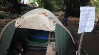 Abdullah Al Mabrur menyemprotkan disenfektan pada tenda yang digunakan saat isolasi mandiri di pinggir sungai Kecu, Ngaran, Mlese, Ceper, Klaten, Jawa Tengah, Senin (20/4/2020).