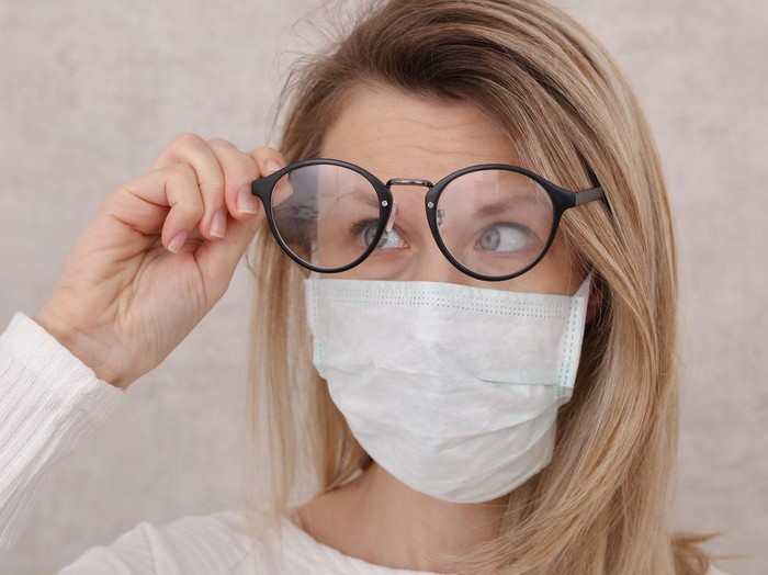 Ilustrasi wanita memakai kacamata dan masker Medical mask and Glasses fogging. Avoid face touching, Coronavirus prevention, Protection.