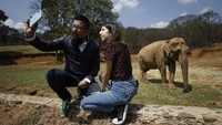Pegawai kebun binatang Gerardo Lopez Santamaria berfoto dengan putrinya Xhanad di depan sebuah kandang gajah, Minggu (19/4) waktu setempat.