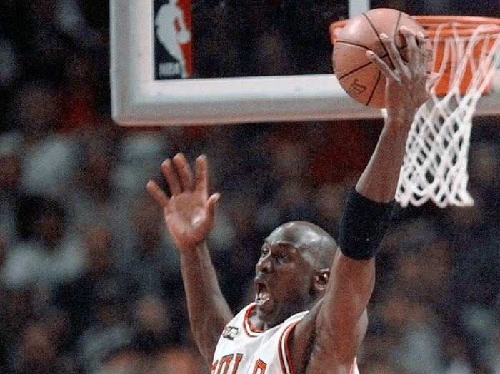 The Last Dance Jordan Basketball FILE - In this June 10, 1998, file photo, Cicago Bulls Michael Jordan reaches high above teammates Dennis Rodman, left, Scottie Pippen, and Scott Burrell (24) for a rebound against the Utah Jazz in the second half of Game 4 in the NBA Finals in Chicago. Jordan described his final NBA championship season with the Chicago Bulls as a “trying year.” “We were all trying to enjoy that year knowing it was coming to an end,” Jordan told Good Morning America on Thursday, April 16, 2020. (AP Photo/Michael S. Green, File)