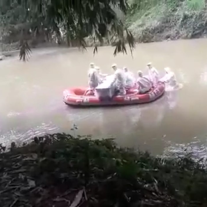 Petugas di Padang antar jenazah ke pemakaman dengan menyeberangi sungai (Instagram @dlh_padang)