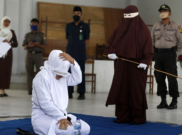 Terpidana (duduk) pelanggar hukum syariat Islam dieksekusi cambuk di Banda Aceh, Aceh, Selasa (21/4/2020). Enam terpidana pelanggar peraturan daerah (qanun) nomor 6/2020 tentang hukum jinayat tetap di eksekusi cambuk ditengah darurat pandemi COVID-19 dengan menjaga jarak sosial (phsycal distancing) dan prosedur kesehatan. ANTARA FOTO/Irwansyah Putra/hp.