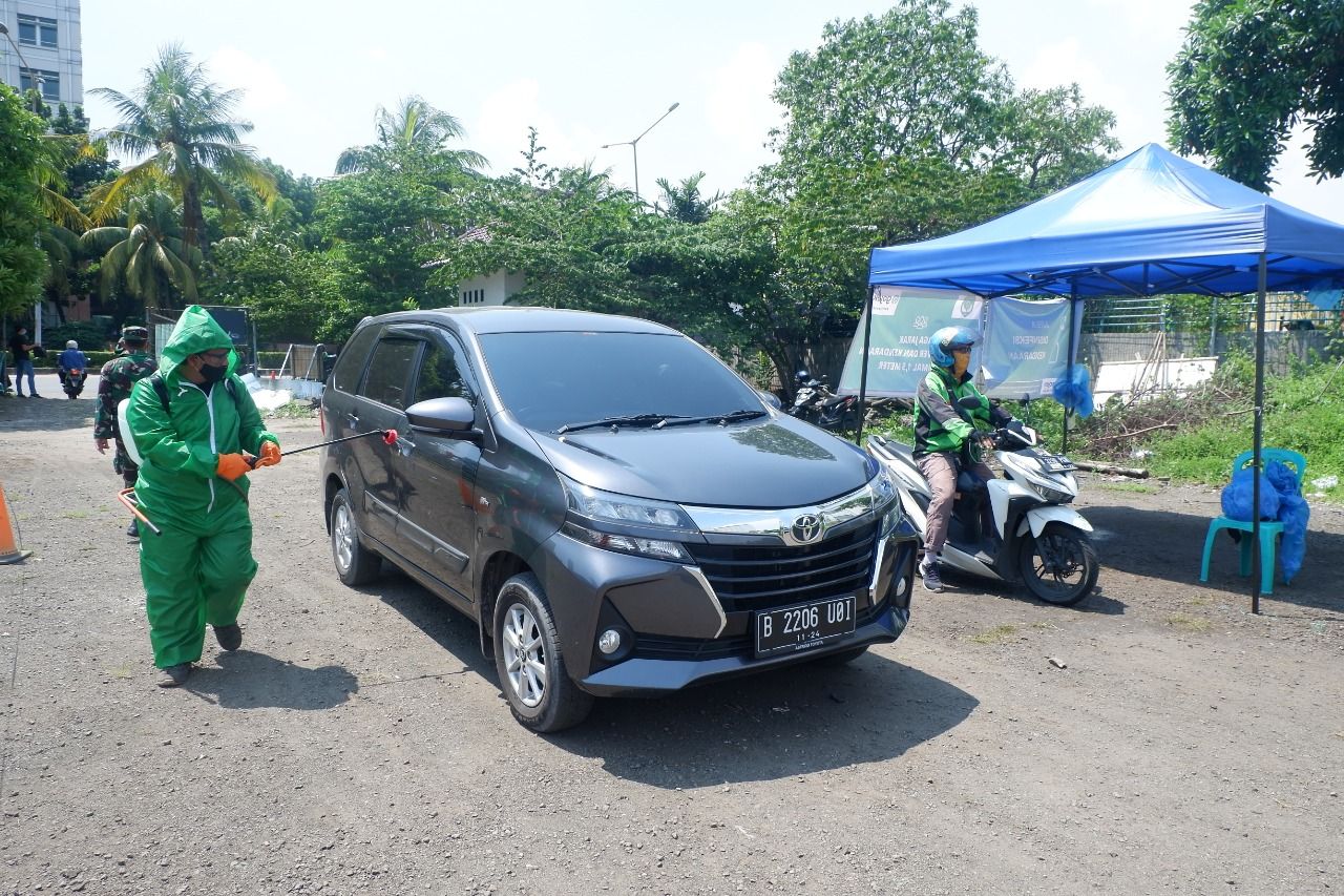 Proses disinfeksi kendaraan di Posko Aman Bersama Gojek