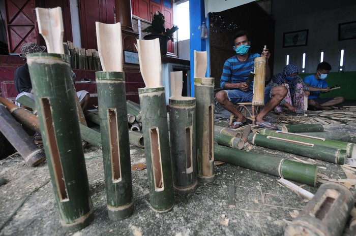 Pekerja membuat kentongan dari bambu di Cokro, Tulung, Klaten, Jawa Tengah, Senin (20/4/2020). Sedikitnya 650 kentongan dibuat untuk memenuhi permintaan di Kota Solo sebagai alat komunikasi tradisional yang dapat digunakan oleh warga saat menjaga keamanan kampung di malam hari di tengah situasi pandemi COVID-19. ANTARA FOTO/Aloysius Jarot Nugroho/wsj.