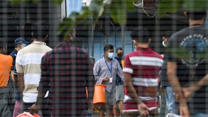 Residents queue for their food at Tuas South foreign workers dormitory that has been placed under government restriction as preventive measure against the spread of the COVID-19 coronavirus in Singapore on April 19, 2020. - Singapore imposed a mandatory stay-home order for migrant workers including in the construction sector for 14 days effective on April 20 due to coronavirus pandemic. (Photo by Roslan RAHMAN / AFP)