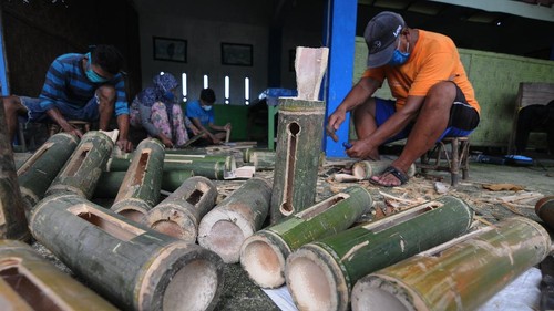 Pekerja membuat kentongan dari bambu di Cokro, Tulung, Klaten, Jawa Tengah, Senin (20/4/2020). Sedikitnya 650 kentongan dibuat untuk memenuhi permintaan di Kota Solo sebagai alat komunikasi tradisional yang dapat digunakan oleh warga saat menjaga keamanan kampung di malam hari di tengah situasi pandemi COVID-19. ANTARA FOTO/Aloysius Jarot Nugroho/wsj.