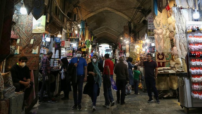 Iranians shop at the Grand Bazaar market in the capital Tehran on April 20, 2020, as the threat of the COVID-19 pandemic lingers ahead of the Muslim holy month of Ramadan. - Ramadan is a period for both self reflection and socialising. Believers fast from dawn to dusk and then gather around a family or community meal each evening of Islams holiest month, which begins later this week and ends with Eid al-Fitr festivities. But this year, the fast-spreading novel coronavirus threatens to dampen Ramadan like never before, with millions locked down across the Middle East. (Photo by ATTA KENARE / AFP)