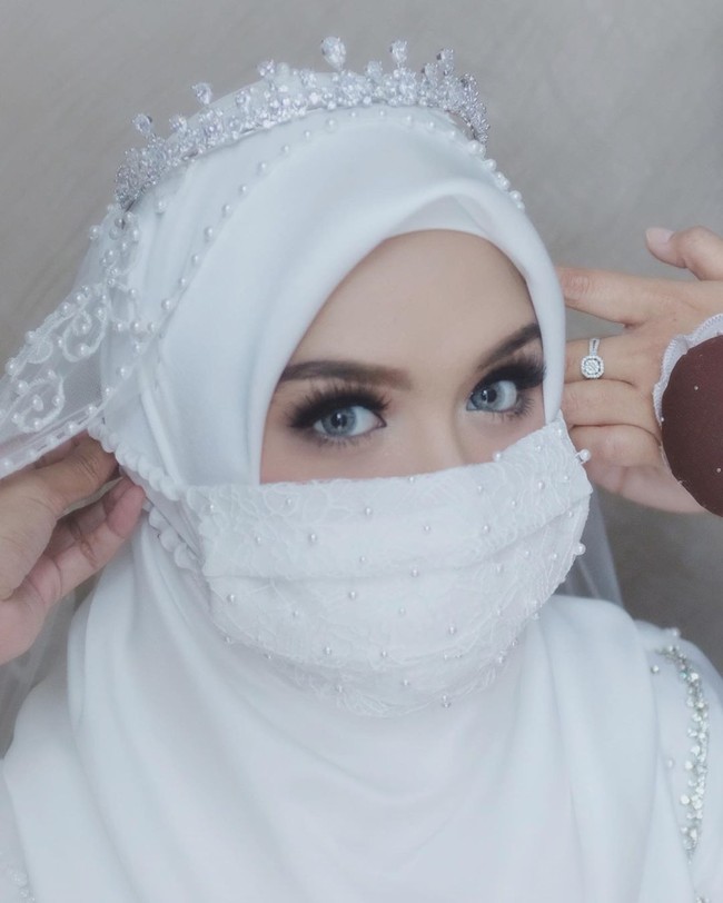 Pada hari pernikahannya Vebby Palwinta tampil memesona dengan gaun pengantin simpel dari Renzi Lazuardi yang dibuat hanya dalam waktu kilat, yaitu lima hari dan mahkota Rasya Shakira. Dia semakin cantik dengan riasan dari Hepi David. Vebby juga berpose memakai masker layaknya pengantin yang menikah di tengah pandemi Corona ini. Foto: Instagram @renzilazuardi