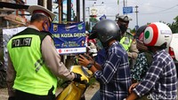 Petugas kepolisian terlihat memberikan teguran kepada pengendara motor yang melanggar aturan PSBB di kawasan Jalan Ir Haji Juanda, Depok, Jawa Barat, Selasa (21/4/2020).