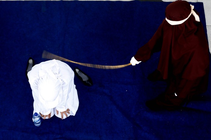 Terpidana (duduk) pelanggar hukum syariat Islam dieksekusi cambuk di Banda Aceh, Aceh, Selasa (21/4/2020). Enam terpidana pelanggar peraturan daerah (qanun) nomor 6/2020 tentang hukum jinayat tetap di eksekusi cambuk ditengah darurat pandemi COVID-19 dengan menjaga jarak sosial (phsycal distancing) dan prosedur kesehatan. ANTARA FOTO/Irwansyah Putra/hp.