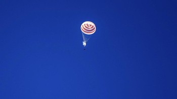 Tampak kapsul Soyuz MS-15 buatan Rusia yang membawa mereka terjung dengan bantuan parasut menuju permukaan Bumi. Foto: AP/Andrey Shelepin