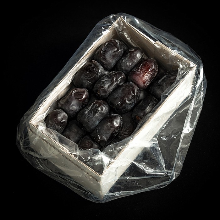 Ramadan dates or kurma for iftar in a box. Isolated on black, studio shot.