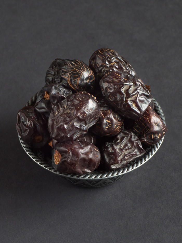 Ramadan dates or kurma for iftar in a box. Isolated on black, studio shot.