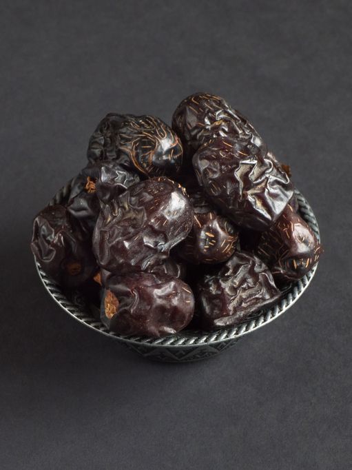 Ramadan dates or kurma for iftar in a box. Isolated on black, studio shot.