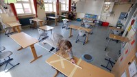 Para pekerja dan staf sekolah dasar Schloss-Schule di Heppenheim, Jerman, mulai membereskan kelas untuk pembukaan kembali sekolah tersebut.