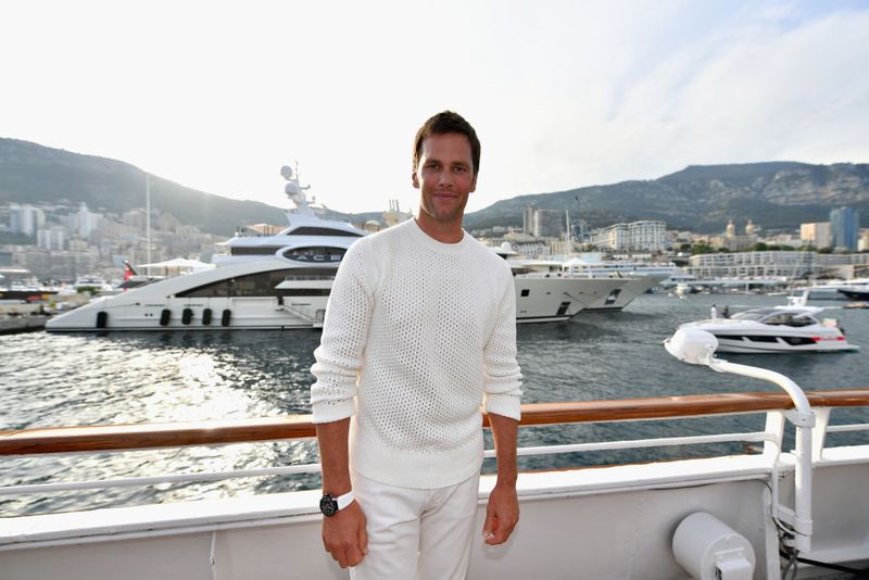 963377730 MONTE-CARLO, MONACO - MAY 26: NFL star Tom Brady poses for a photo after throwing a ball to Daniel Ricciardo of Australia and Red Bull Racing on the TAG Heuer boat after qualifying for the Monaco Formula One Grand Prix at Circuit de Monaco on May 26, 2018 in Monte-Carlo, Monaco. (Photo by Dan Mullan/Getty Images)