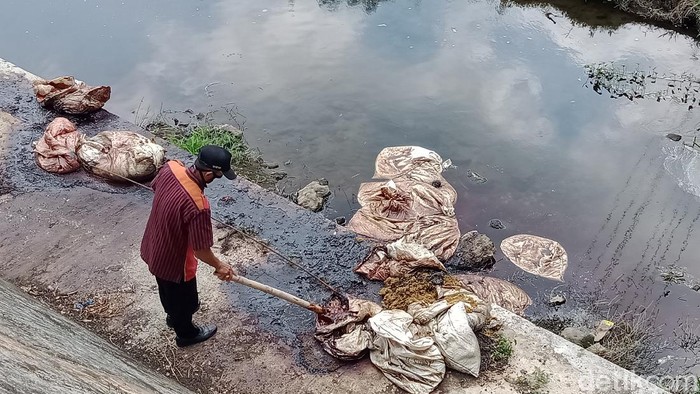 Tim Pemkab Klaten mengecek isi karung bersimbah darah di bawah jembatan Pandan Simping, Kamis (23/4/2020).