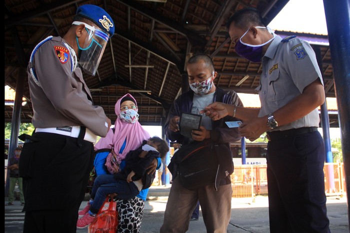 Sejumlah calon penumpang bersiap naik bus di area Terminal Jatijajar, Depok, Jawa Barat, Kamis (23/4/2020). Pemerintah memutuskan kebijakan larangan mudik Lebaran 2020 bagi masyarakat mulai berlaku Jumat (24/4) guna memutus mata rantai penyebaran COVID-19. ANTARA FOTO/Asprilla Dwi Adha/aww.