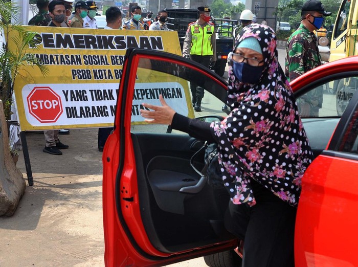 Warga turun dan pindah tempat duduk saat pemeriksaan kepatuhan Pembatasan Sosial Berskala Besar (PSBB) di jalan KH Sholeh Iskandar, Kota Bogor, Jawa Barat, Senin (20/4/2020). Polresta Bogor Kota mencatat sedikitnya 312 pelanggaran terjadi selama penerapan PSBB di Kota Bogor seperti tidak menggunakan masker, jumlah penumpang di dalam angkutan umum melebihi kapasitas 50 persen dan tidak menjaga jarak di dalam kendaraan roda empat.