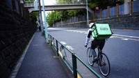 Mitra UBER menggowes sepedanya di jalanan yang sepi untuk mengirimkan pesanan konsumen. Saat ini Jepang telah memperluas status keadaan darurat di luar Tokyo yang mencakup Osaka, dan 5 prefektur lainnya untuk mencegah penyebaran Corona. AP Photo/Eugene Hoshiko.