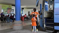 Seorang penumpang memasangkan masker pada anak saat menunggu keberangkatan menjelang bulan puasa di Terminal Mengwi, Badung, Bali, Kamis (23/4/2020). Pemprov Bali telah berkoordinasi dengan Ketua Dewan Masjid, MUI Provinsi Bali dan Kanwil Agama agar warga muslim di Bali tetap bertahan. ANTARA FOTO/Nyoman Hendra Wibowo