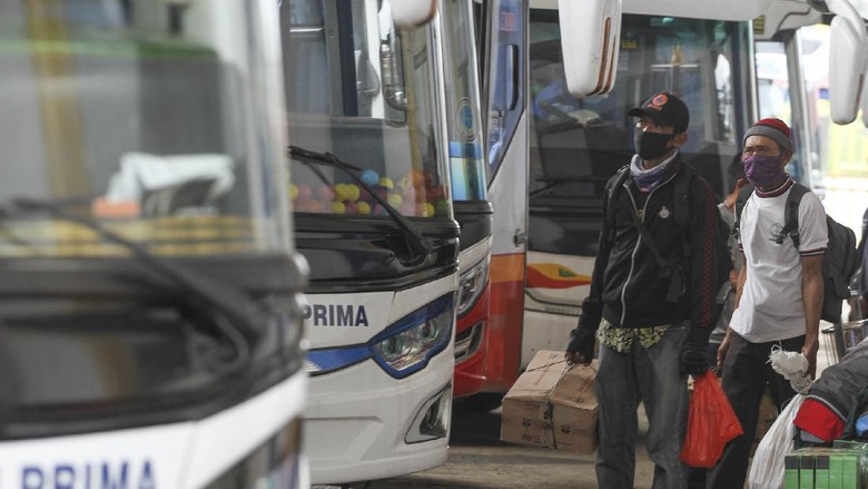 PENUMPANG BEPERGIAN JELANG LARANGAN MUDIK Sejumlah calon penumpang bersiap naik bus di area Terminal Jatijajar, Depok, Jawa Barat, Kamis (23/4/2020). Pemerintah memutuskan kebijakan larangan mudik Lebaran 2020 bagi masyarakat mulai berlaku Jumat (24/4) guna memutus mata rantai penyebaran COVID-19. ANTARA FOTO/Asprilla Dwi Adha/aww.