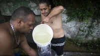 Warga tengah mandi di pinggir jalan di kawasan Caracas, Venezuela, kemarin. Ditengah perayaan Hari Bumi Internasional pada Rabu (22/4).