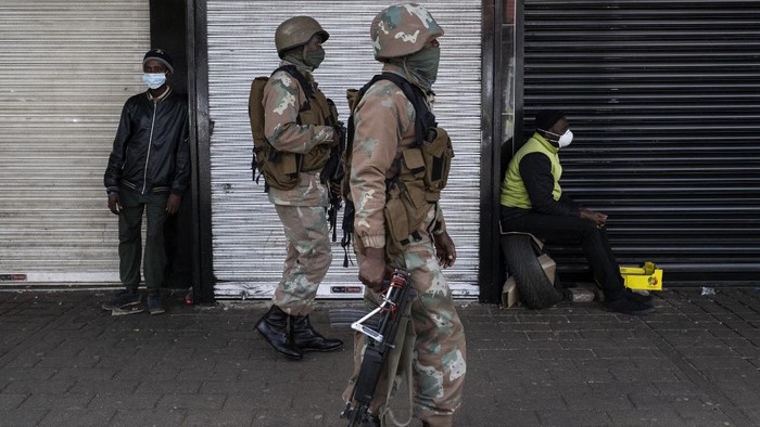 South African National Defence Force (SANDF) soldiers patrol the streets in Yeoville, Johannesburg, on April 18, 2020, during a joint operation between the South African Police Service (SAPS) and the South African National Defence Force (SANDF) to enforce a national lockdown to help curb the spread of the COVID-19 coronavirus outbreak. (Photo by WIKUS DE WET / AFP)