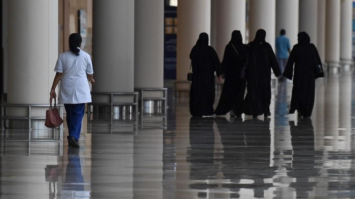 Emirati women walk in a nearly deserted shopping centre during the novel coronavirus pandemic crisis in the Gulf Emirate of Dubai, on April 19, 2020. (Photo by KARIM SAHIB / AFP)