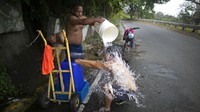 Warga tengah mandi di pinggir jalan di kawasan Caracas, Venezuela, kemarin. Ditengah perayaan Hari Bumi Internasional, banyak warga Caracas kesulitan air bersih.