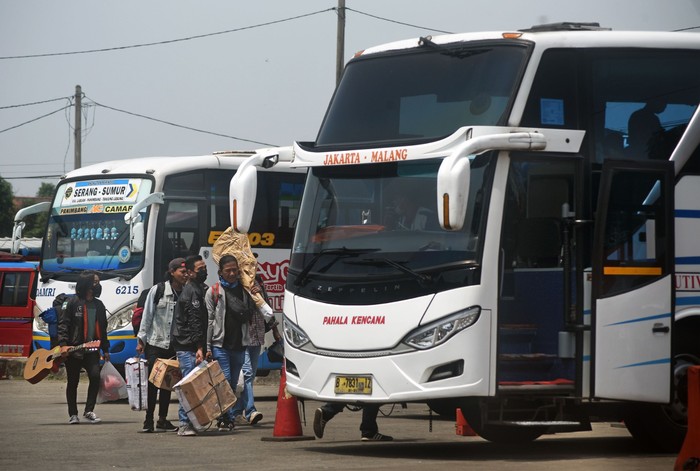 Sejumlah calon penumpang bersiap naik bus di area Terminal Jatijajar, Depok, Jawa Barat, Kamis (23/4/2020). Pemerintah memutuskan kebijakan larangan mudik Lebaran 2020 bagi masyarakat mulai berlaku Jumat (24/4) guna memutus mata rantai penyebaran COVID-19. ANTARA FOTO/Asprilla Dwi Adha/aww.