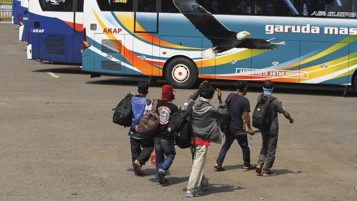 Sejumlah calon penumpang bersiap naik bus di area Terminal Jatijajar, Depok, Jawa Barat, Kamis (23/4/2020). Pemerintah memutuskan kebijakan larangan mudik Lebaran 2020 bagi masyarakat mulai berlaku Jumat (24/4) guna memutus mata rantai penyebaran COVID-19. ANTARA FOTO/Asprilla Dwi Adha/aww.