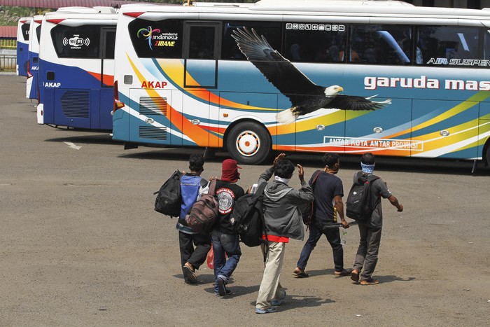 Sejumlah calon penumpang bersiap naik bus di area Terminal Jatijajar, Depok, Jawa Barat, Kamis (23/4/2020). Pemerintah memutuskan kebijakan larangan mudik Lebaran 2020 bagi masyarakat mulai berlaku Jumat (24/4) guna memutus mata rantai penyebaran COVID-19. ANTARA FOTO/Asprilla Dwi Adha/aww.